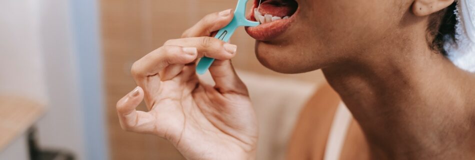 Person cleaning teeth with dental floss