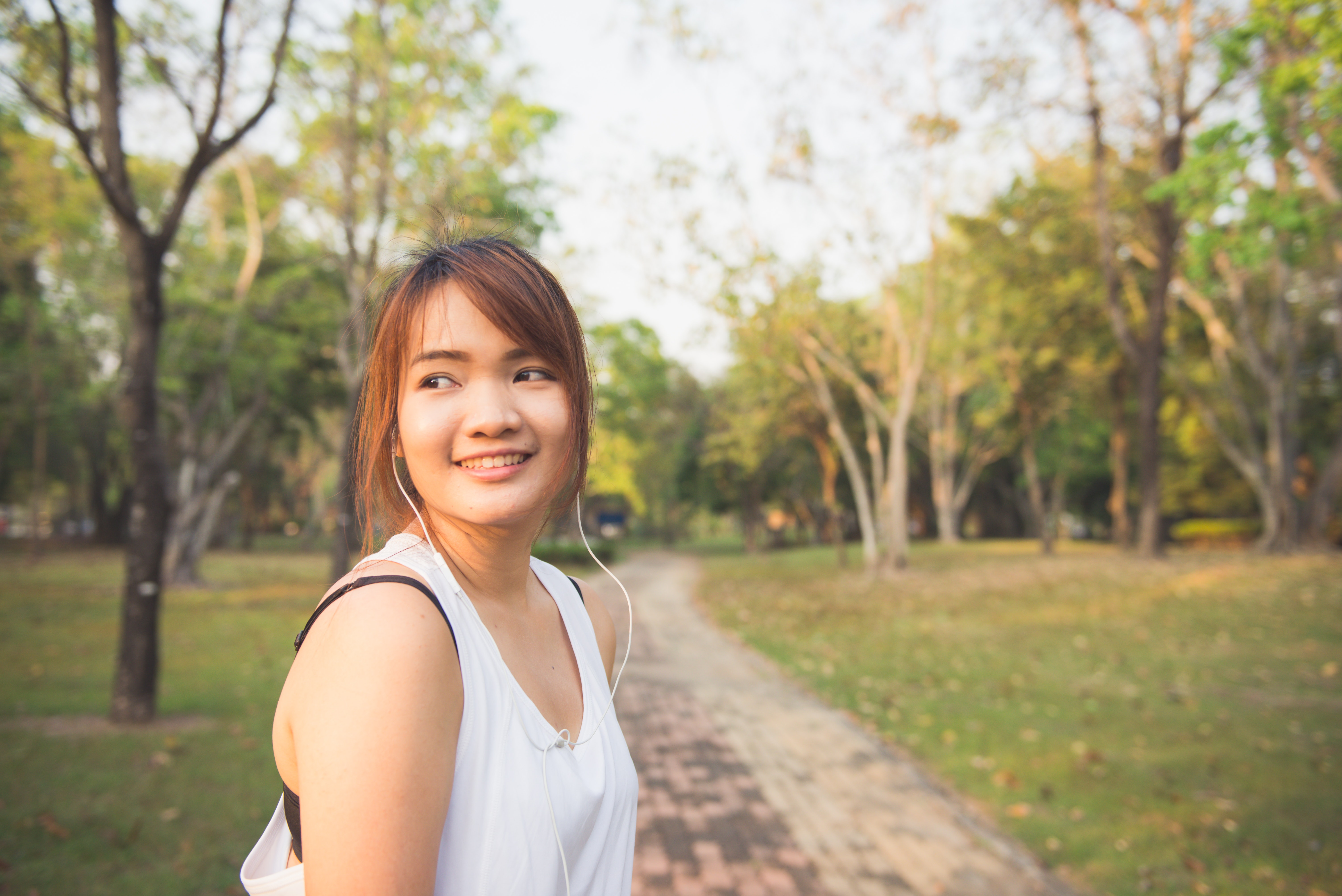 Woman in White Tank Top Standing Outdoors