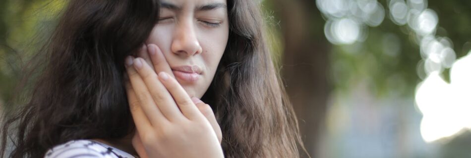 Person putting their hands on their face like it hurts and grimacing.