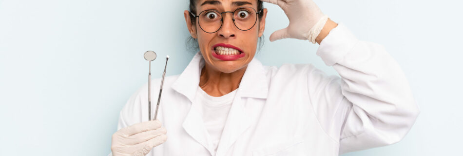 Hispanic woman feeling stressed, holding dental instruments.