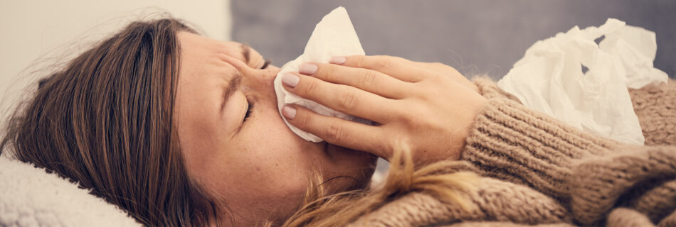 Sick woman with seasonal infection lying in bed.